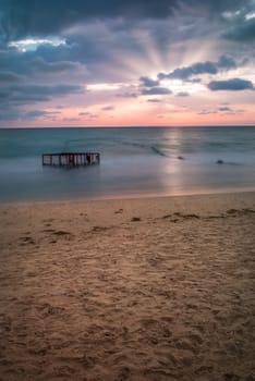 Tropical Beach with Empty Cage in the Sea at Colorful Sunset