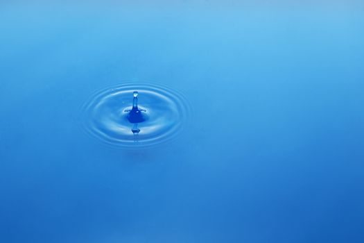 Water drop on blue background, waves on water
