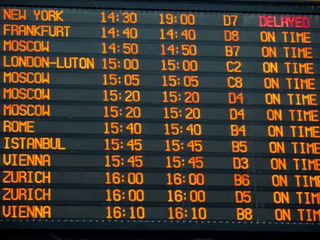 Flights information board with arrivals and departures details  in an international  airport terminal