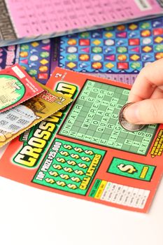 Coquitlam BC Canada - May 25, 2014 : Scratching lottery tickets. The British Columbia Lottery Corporation has provided government sanctioned lottery games in British Columbia since 1985. 