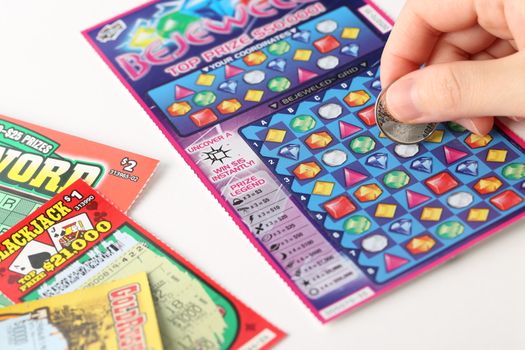 Coquitlam BC Canada - May 25, 2014 : Scratching lottery tickets. The British Columbia Lottery Corporation has provided government sanctioned lottery games in British Columbia since 1985. 