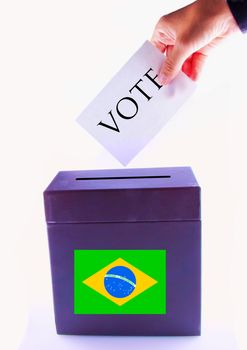 Urn for vote, with male hand posting vote and Brazil banner