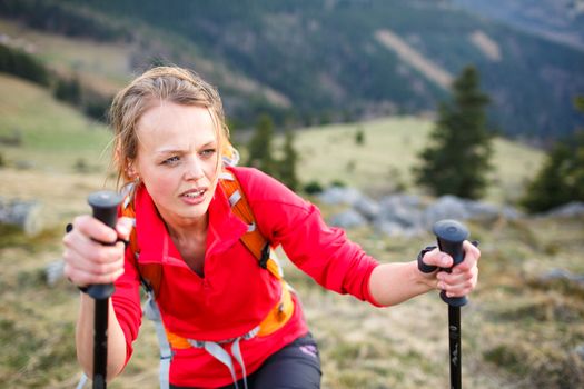 Pretty, young female hiker having a tough walk uphill