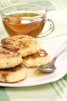 Delicious homemade cheese pancakes with honey closeup