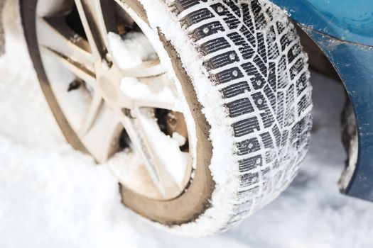 transportation, winter and vehicle concept - closeup of car winter tire