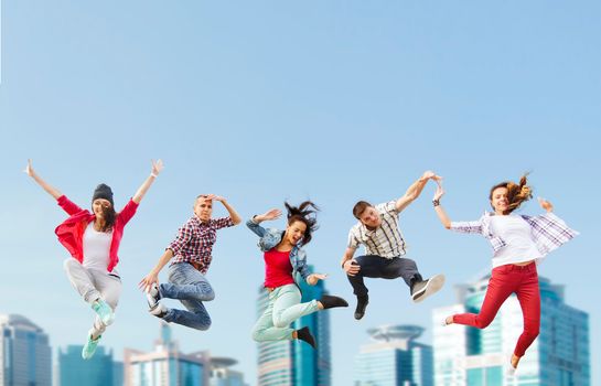 summer, sport, dancing and teenage lifestyle concept - group of teenagers jumping