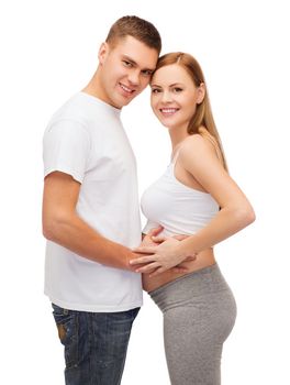 pregnancy, parenthood and happiness concept - happy young family expecting child