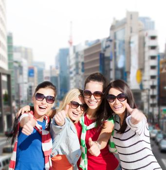 summer, holidays, vacation, happy people concept - beautiful teenage girls or young women showing thumbs up