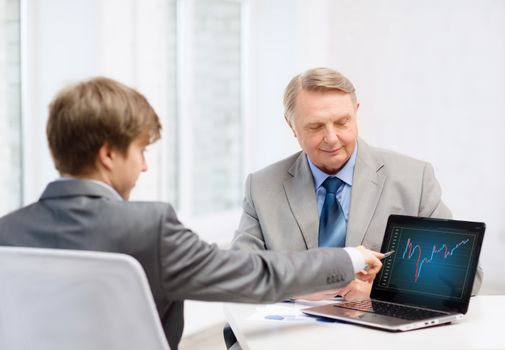 business, advertisement, technology and office concept - older man and young man with laptop computer in office