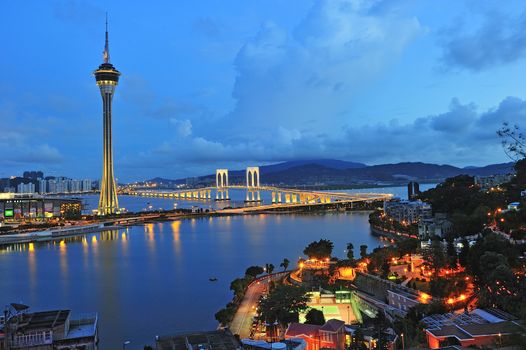 Urban landscape of Macau with famous traveling tower under blue sky near river in Macao, Asia.