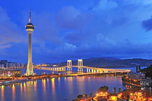 Urban landscape of Macau with famous traveling tower under blue sky near river in Macao, Asia.