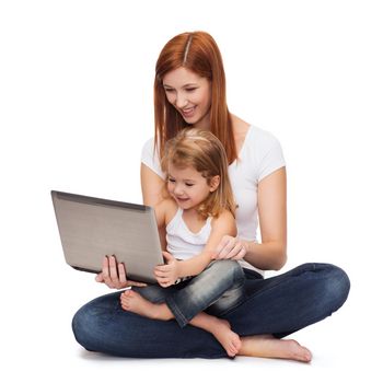 childhood, parenting and technology concept - happy mother with adorable little girl with laptop