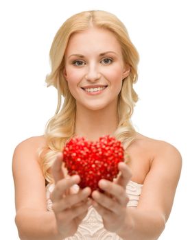 health, charity and love concept - smiling woman giving small red heart