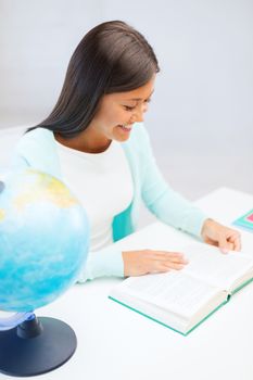 education and school, travel concept - female teacher with globe and book