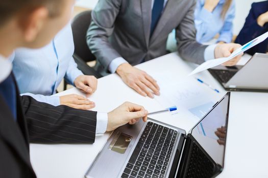 business and office concept - close up of business team with files and laptop computer in office