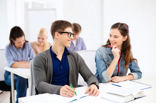 school and education concept - group of smiling students with notebooks at school