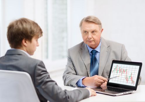 business, advertisement, technology and office concept - older man and young man with laptop computer in office