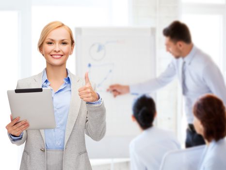 business, internet and technology concept - smiling woman with tablet pc computer showing thumbs up at office