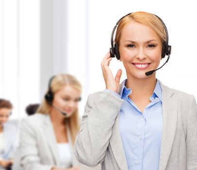 business, technology and call center concept - friendly female helpline operator with headphones at office