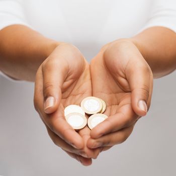 money and finances concept - close up of womans cupped hands showing euro coins