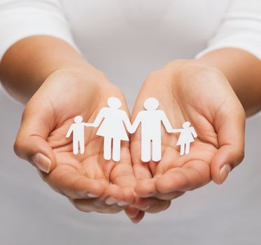 love and relationships concept - closeup of womans cupped hands showing paper man family
