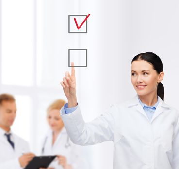 healthcare, medicine and technology concept - smiling female doctor pointing to checkbox
