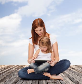 childhood, parenting and technology concept - happy mother with adorable little girl and tablet pc computer