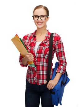 education and people concept - female student in eyeglasses with bag and folders