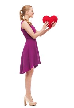 beauty, fashion, love and happy people concept - young woman in purple dress and high heels and red heart