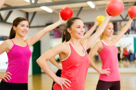 fitness, sport, training, gym and lifestyle concept - group of smiling people working out with stability balls in the gym