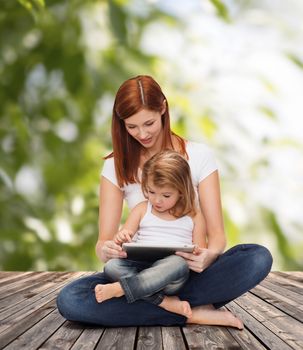 childhood, parenting and technology concept - happy mother with adorable little girl and tablet pc computer