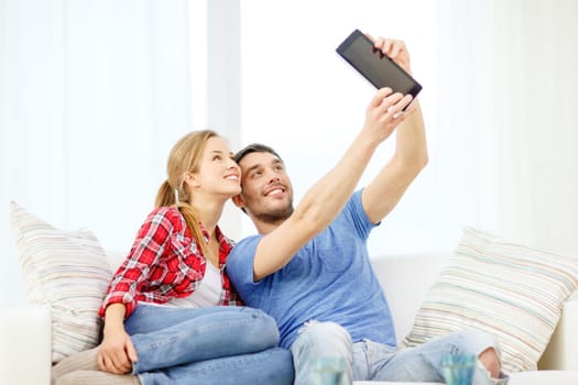 home, technology and relationships concept - smiling couple with tablet pc computer at home