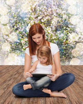 childhood, parenting and technology concept - happy mother with adorable little girl and tablet pc computer