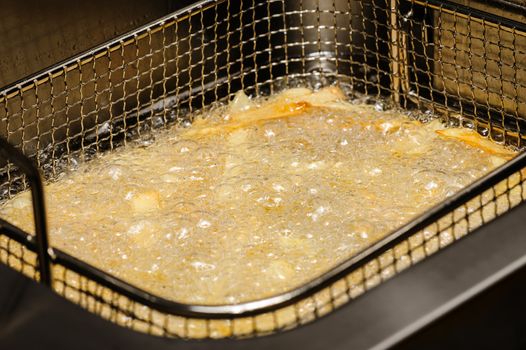 french fries being cooked in electric fryer