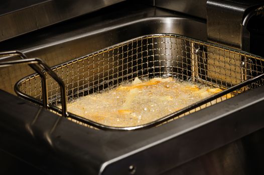 french fries being cooked in electric fryer