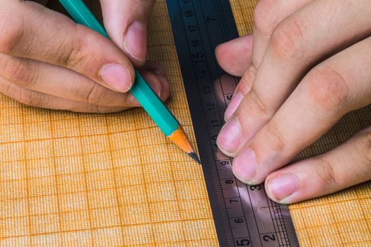 draftsman draws on a ruler on the graph paper