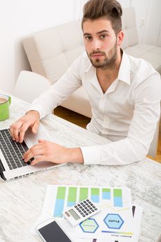 A young man checking his business statistics at home