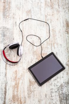 A Tablet PC with headphones on the Table.