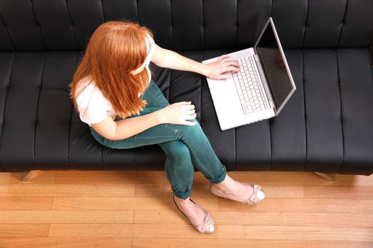 A young, brazilian woman surfing on the Internet with a Laptop.  