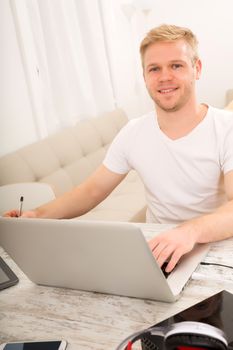 A young caucasian man working in his home office.