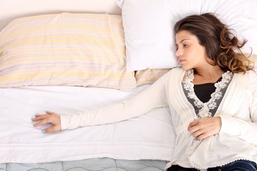 A woman lying alone on the bed.