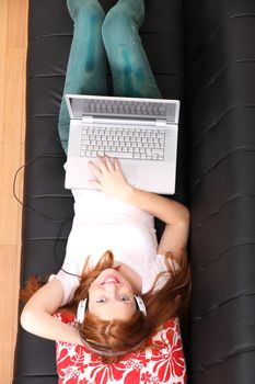 A young woman surfing on the Internet with a Laptop.  