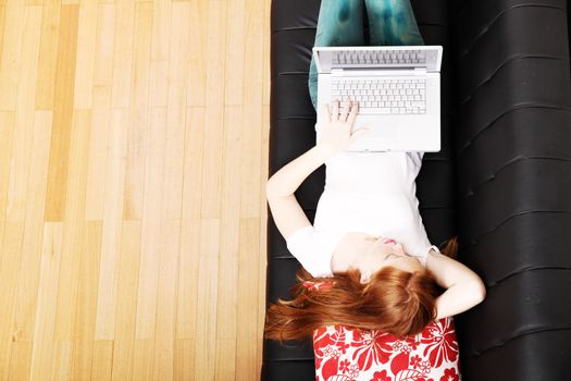 A young woman surfing on the Internet with a Laptop.  