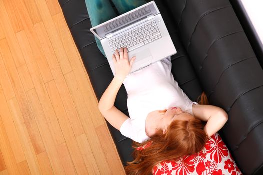 A young woman surfing on the Internet with a Laptop.  