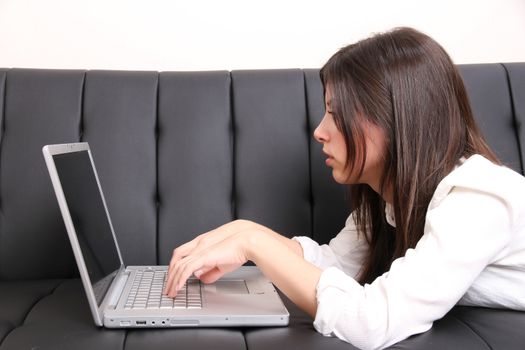 A young woman surfing on the Internet with a Laptop.  
