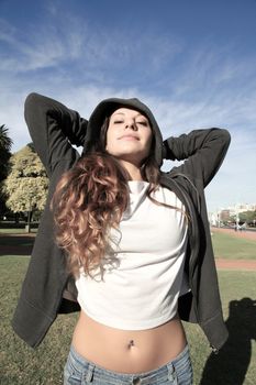 A young woman enjoying the sunlight in the Park.			
