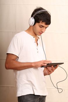 A young, latin man playing with a Tablet PC
