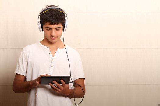 A young, latin man playing with a Tablet PC 