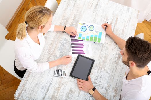 A young couple organizing their financial situation at home.