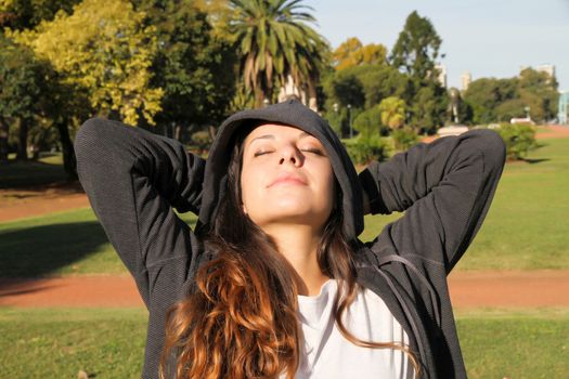 A young woman enjoying the sunlight in the Park.			
